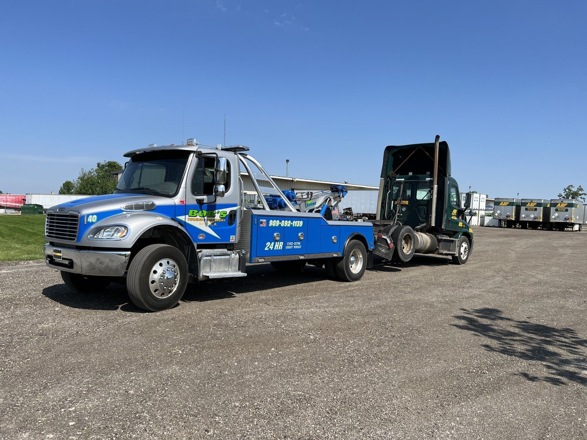 Blue tow truck with black truck
