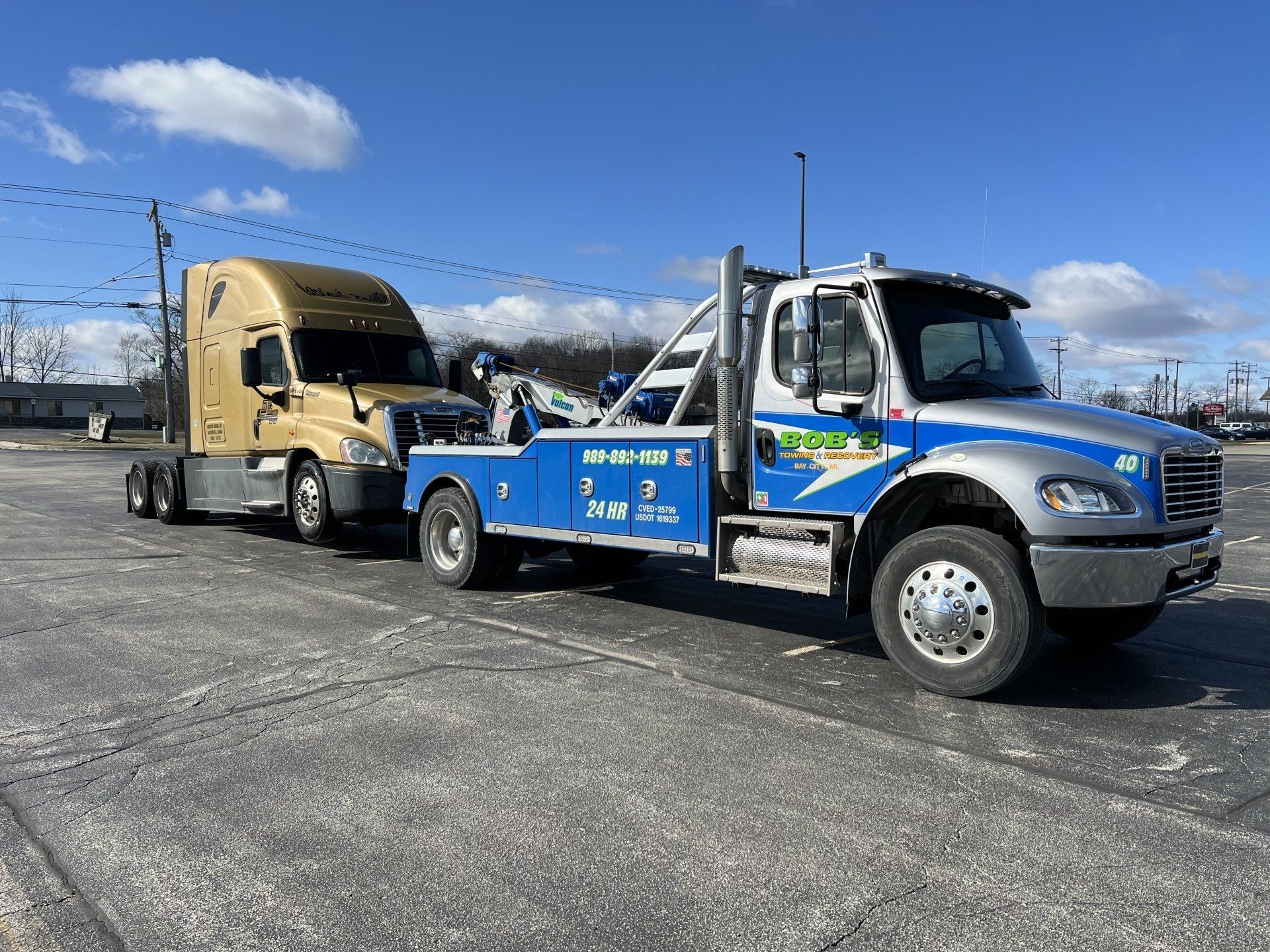 Blue tow truck with a small trailer