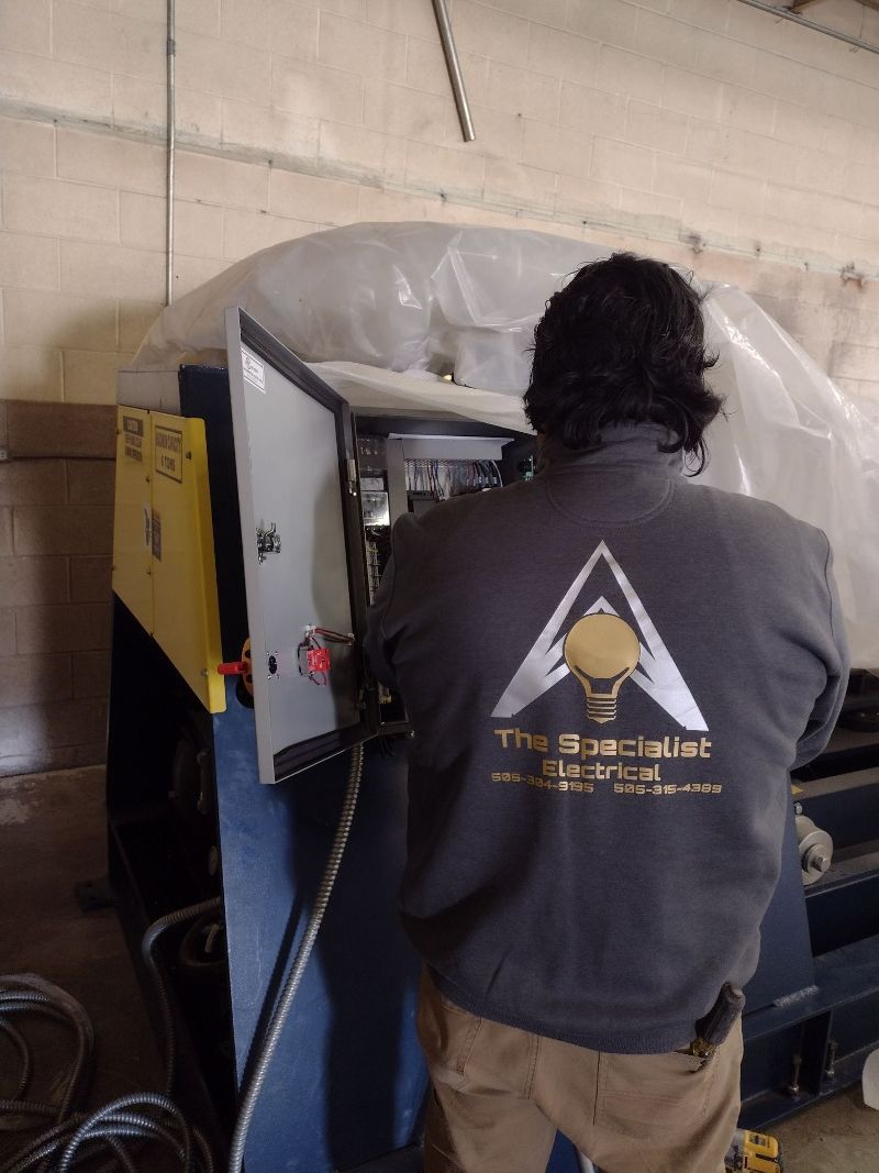 A man standing in front of a machine with a triangle logo on his back