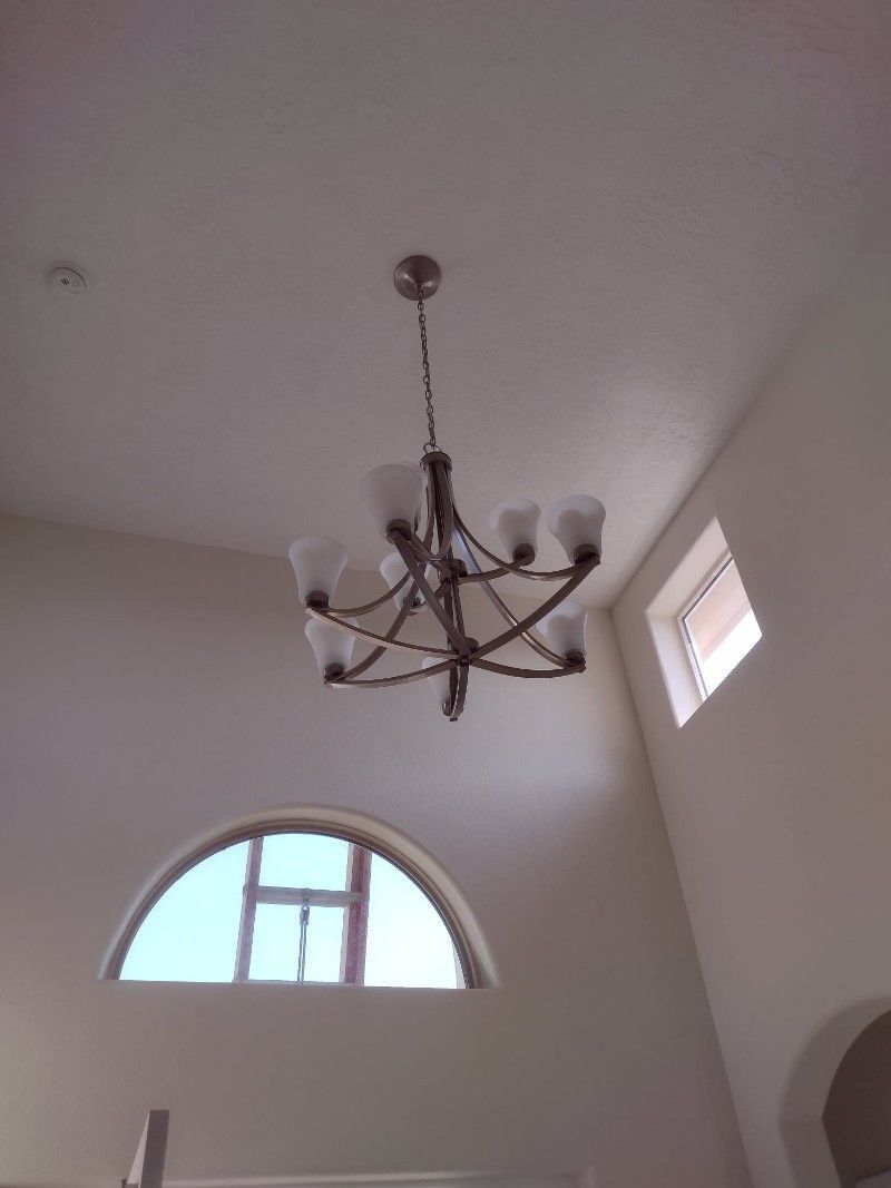 A chandelier is hanging from the ceiling above a window