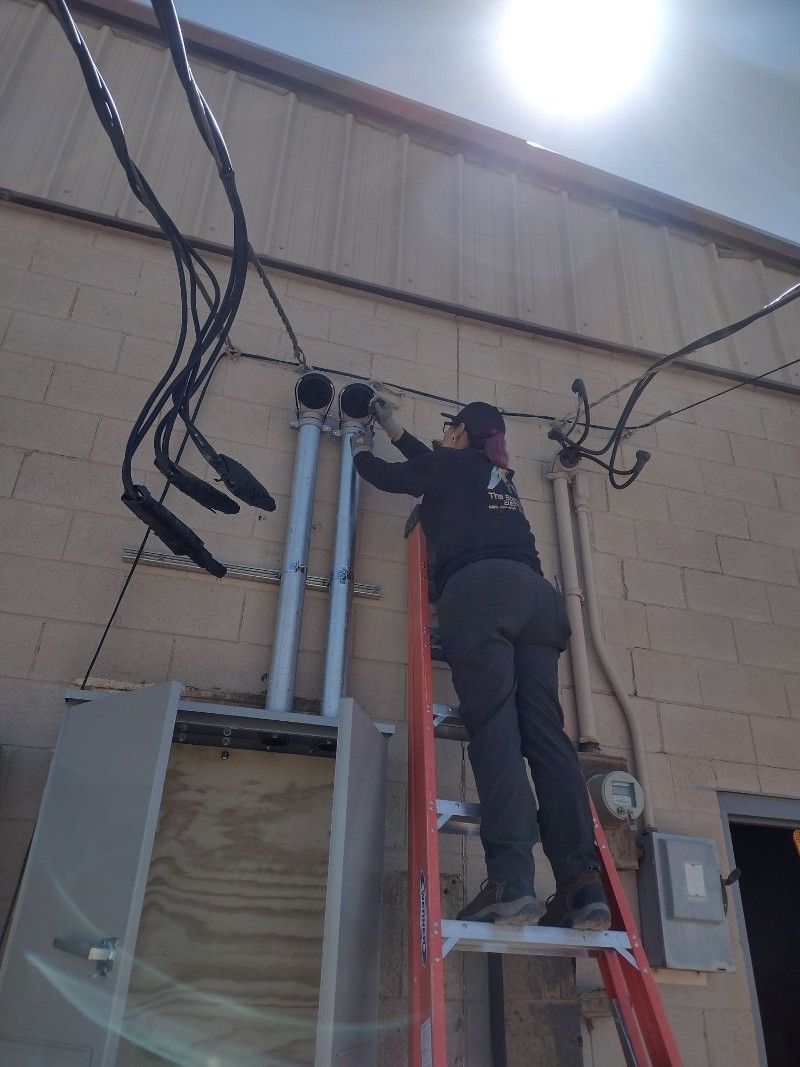 A man is standing on a ladder working on a building.