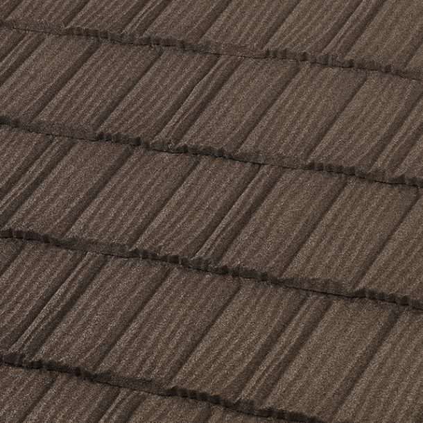 Close-up of a brown metal roof with a textured surface. The tiles are rectangular and overlap.
