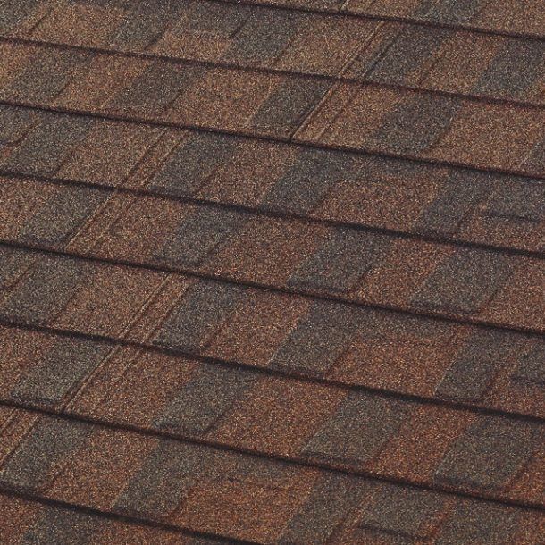 Close-up of a roof covered in overlapping brown and dark gray asphalt shingles.