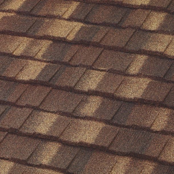Brown asphalt shingles on a roof, with shadowed ridges and varying shades of brown and tan.