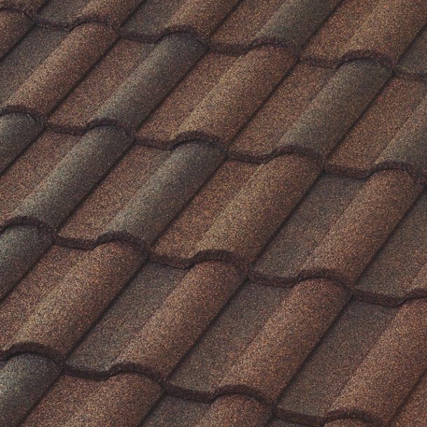 Close-up view of a brown tile roof with a textured, speckled appearance. The tiles are interlocking, creating a pattern.