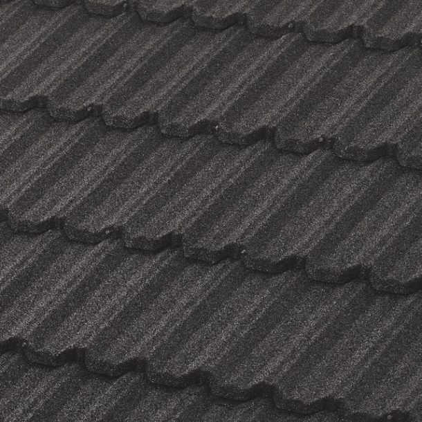 Close-up of dark gray, textured metal roofing tiles with a wavy, interlocking pattern.