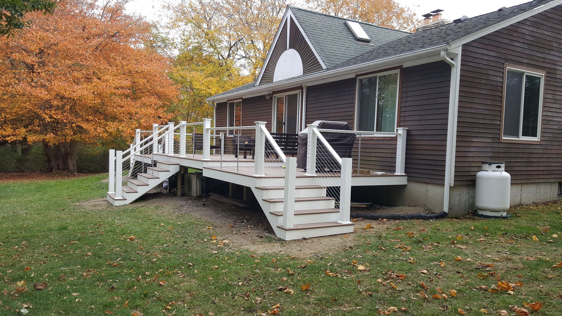 A house with a large deck and stairs in front of it.