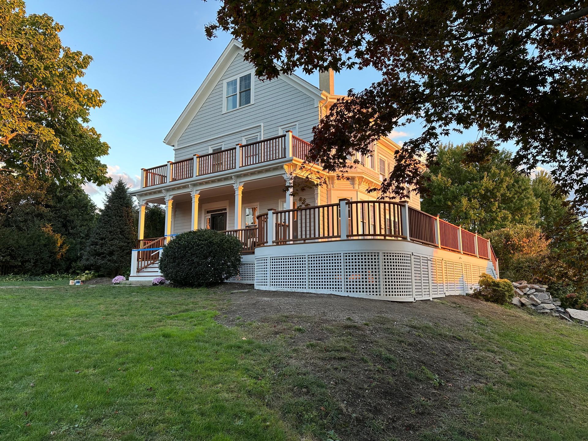 A large white house with a large porch and deck.