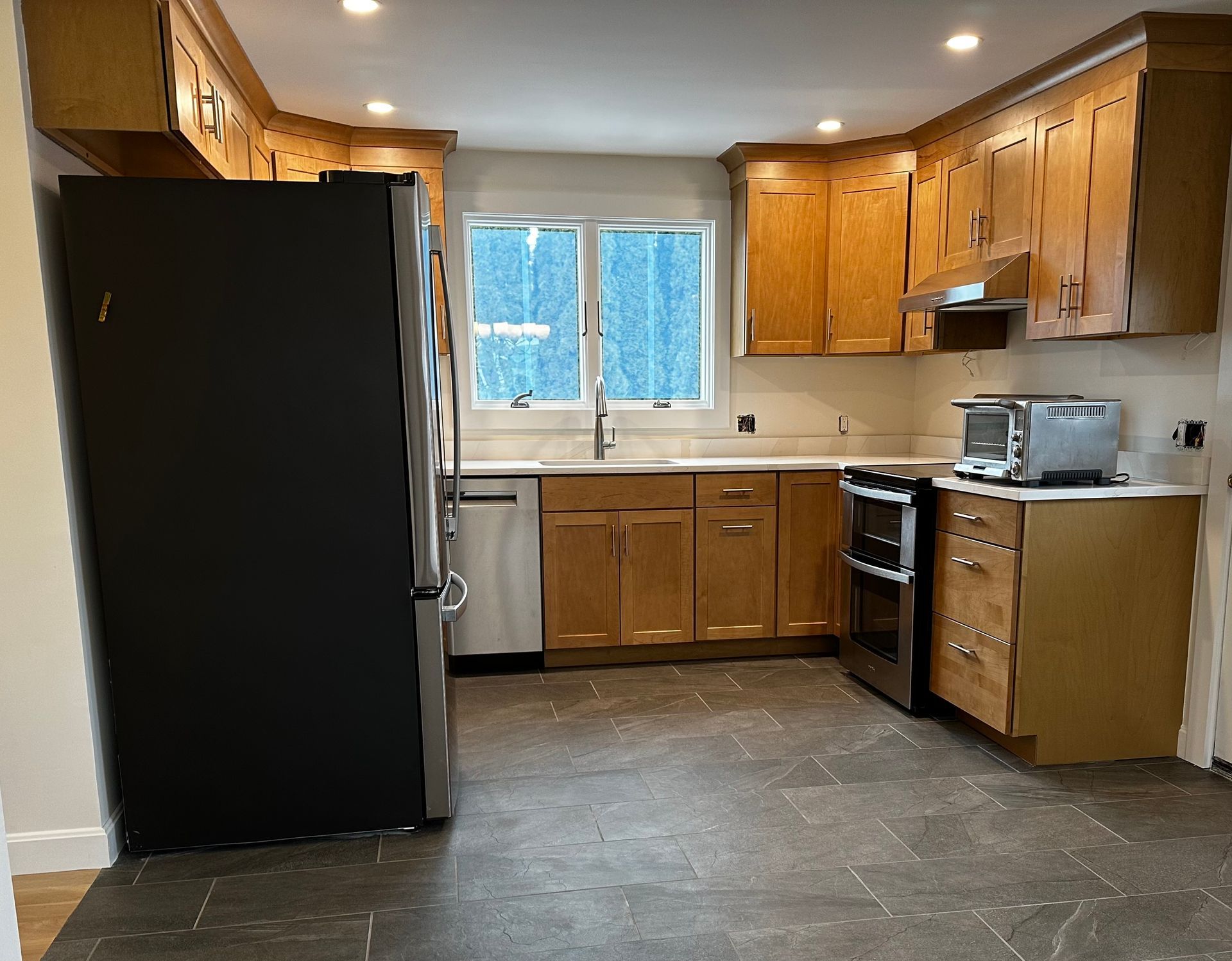 A kitchen with wooden cabinets and stainless steel appliances.