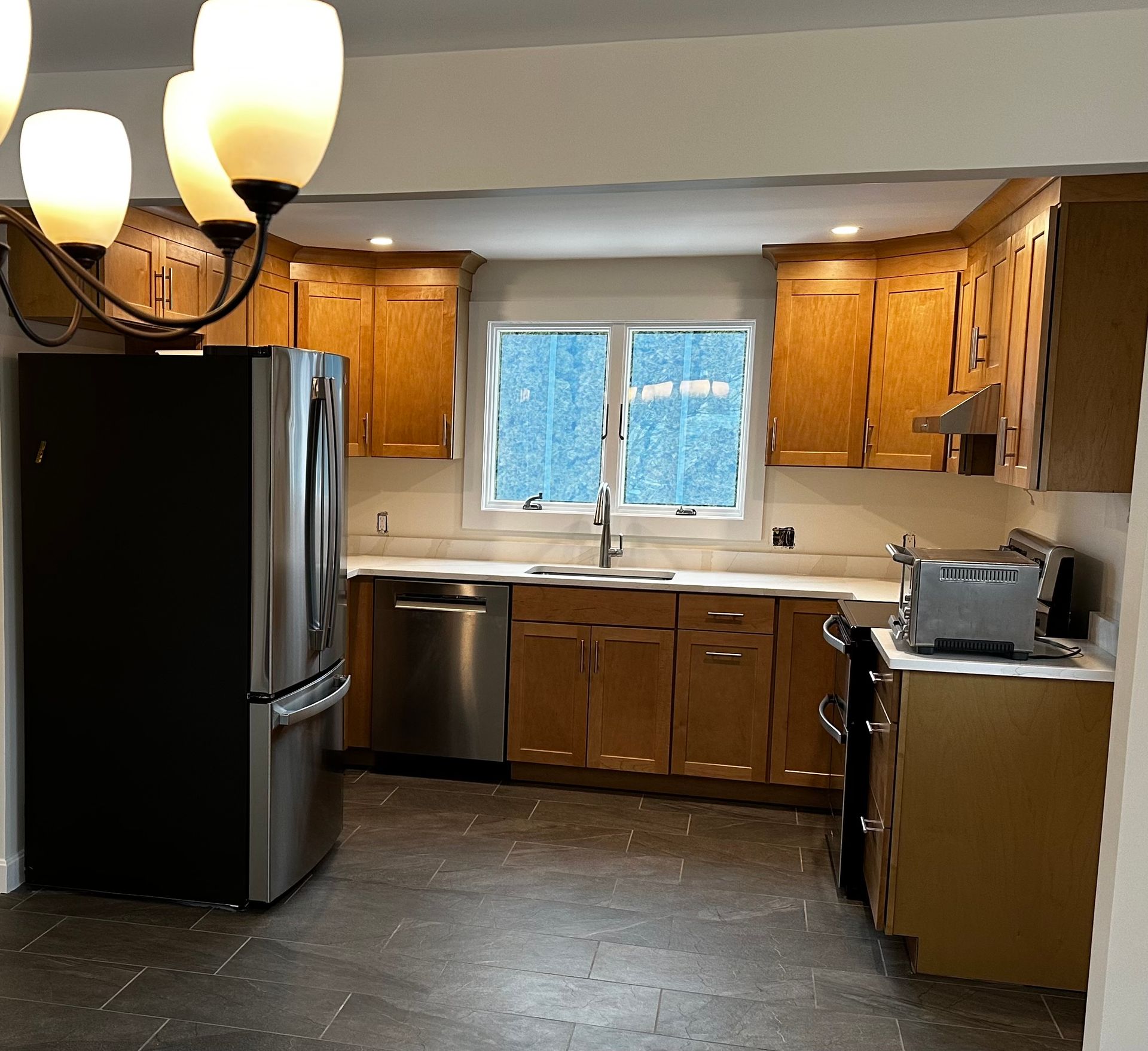 A kitchen with stainless steel appliances and wooden cabinets.