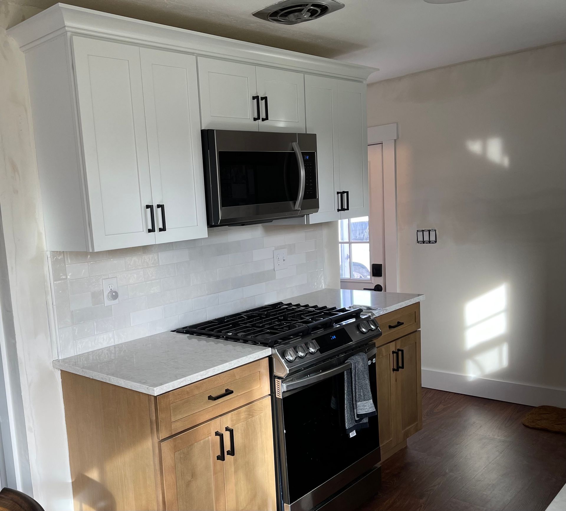 A kitchen with white cabinets and stainless steel appliances.