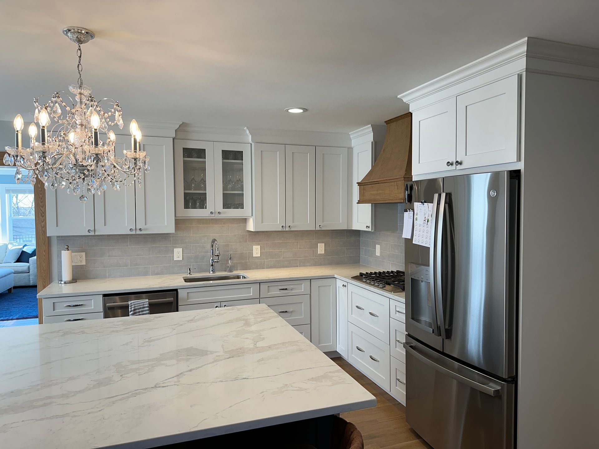 A kitchen with white cabinets and a stainless steel refrigerator.