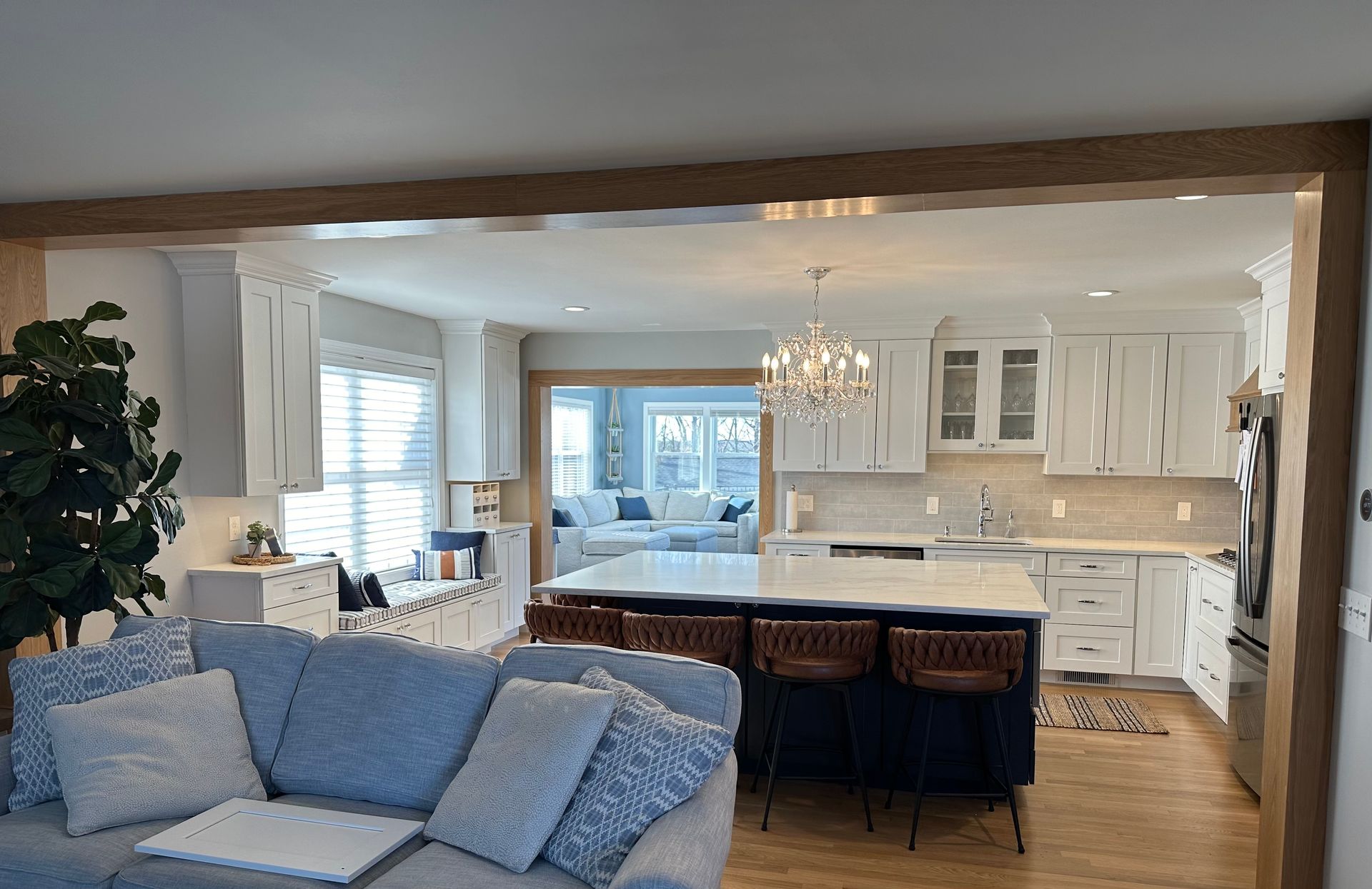 A living room with a couch and a kitchen in the background.