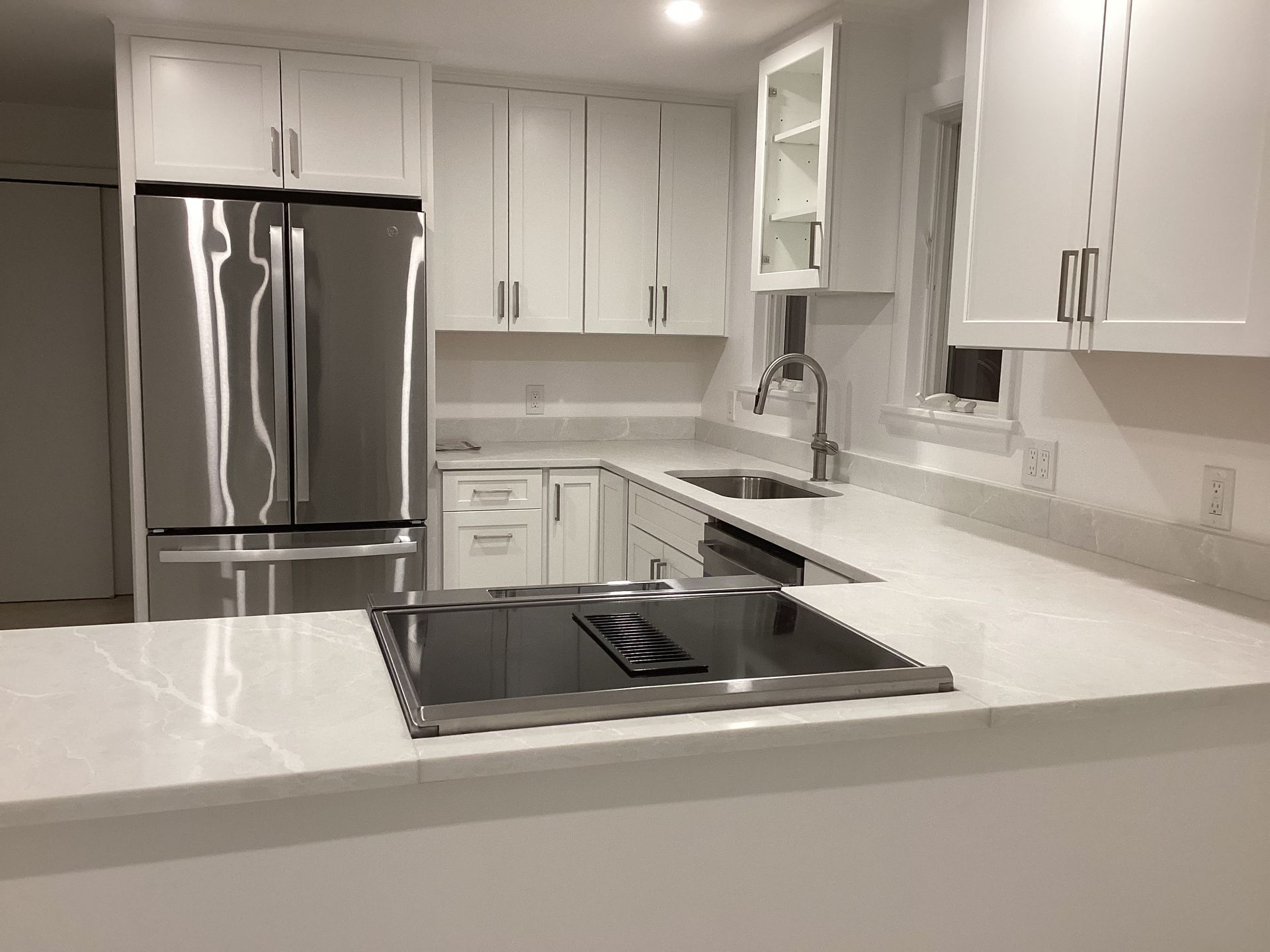 A kitchen with white cabinets and stainless steel appliances.