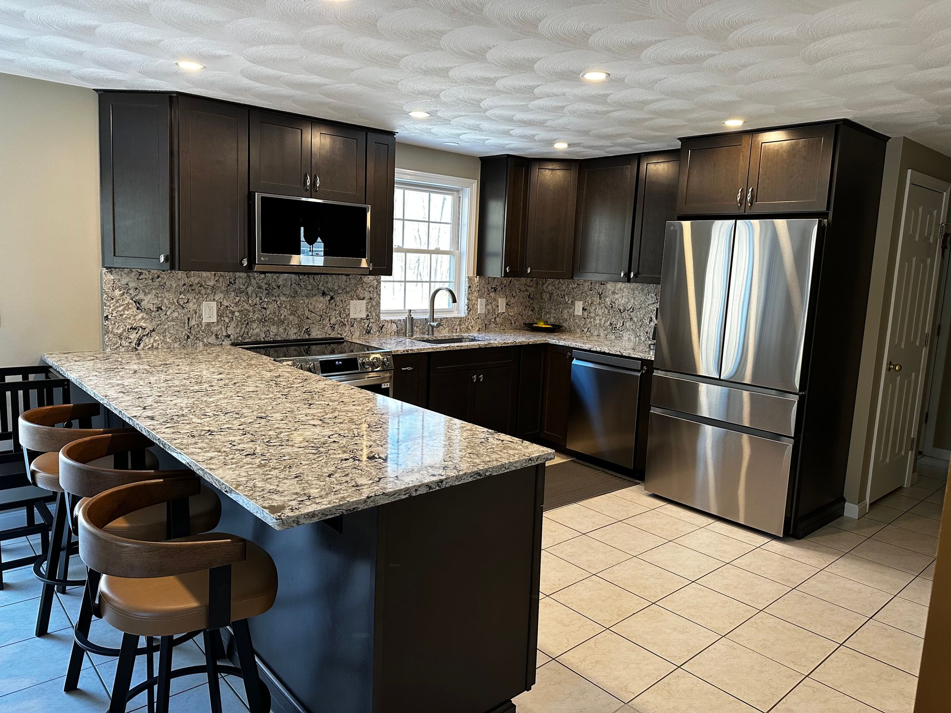 A kitchen with granite countertops and stainless steel appliances.