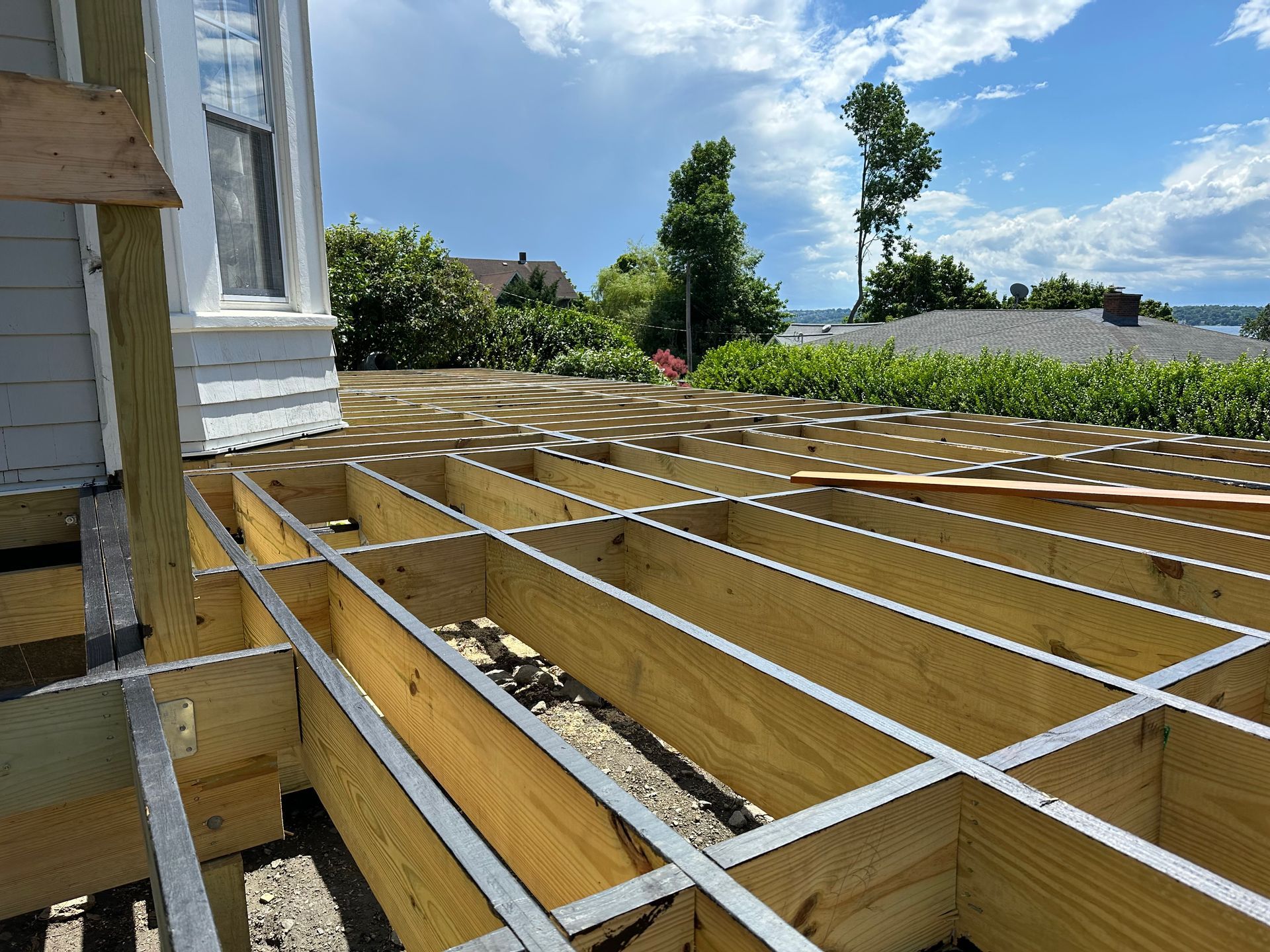 A wooden deck is being built in front of the house.