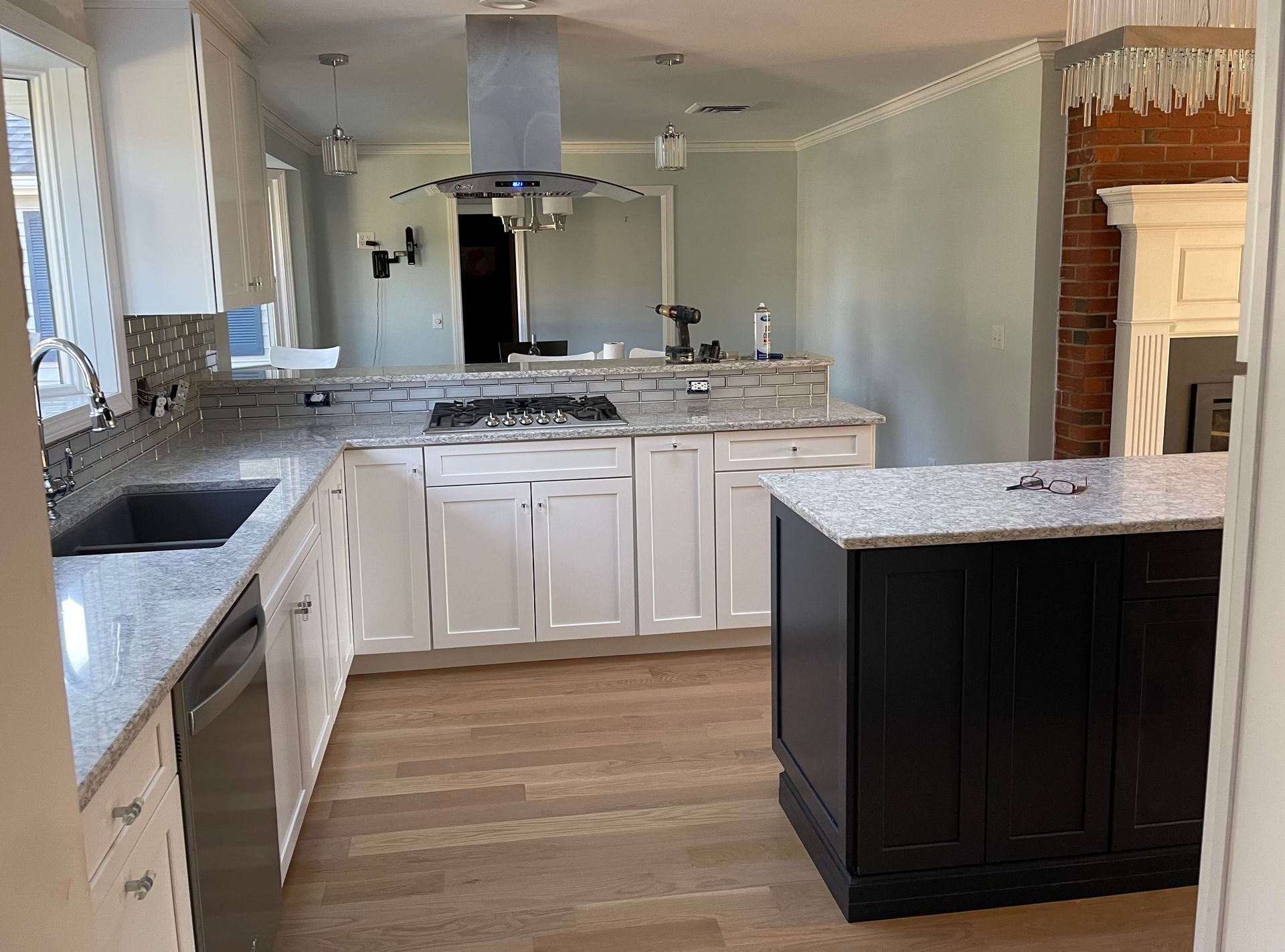 A kitchen with white cabinets and granite countertops.