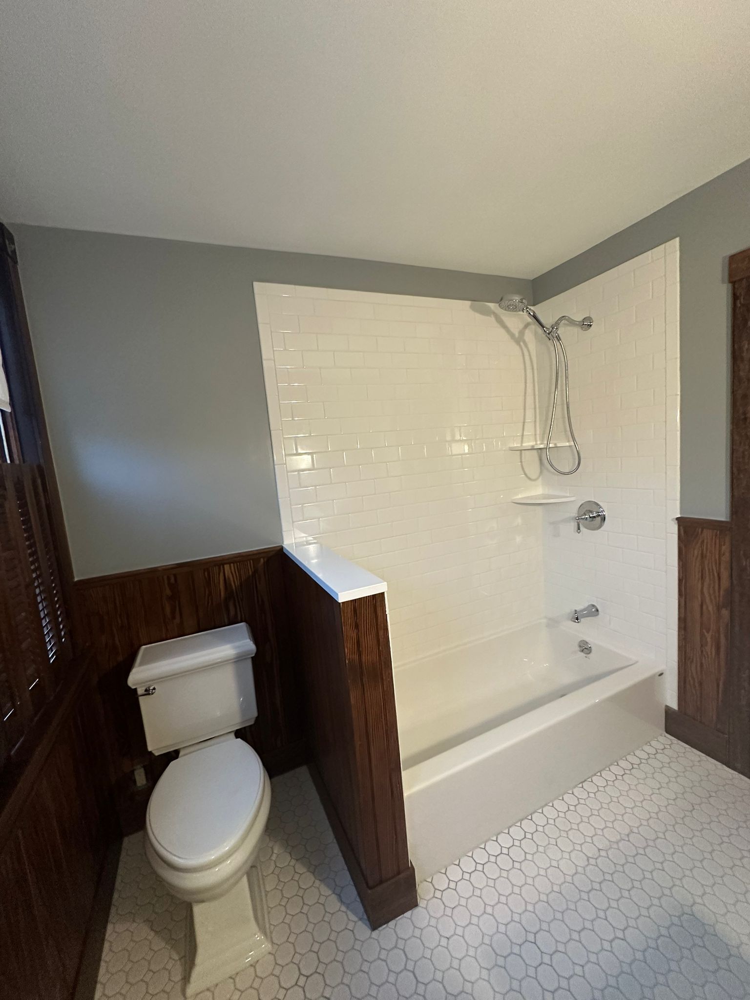A bathroom with a toilet, bathtub, and shower.