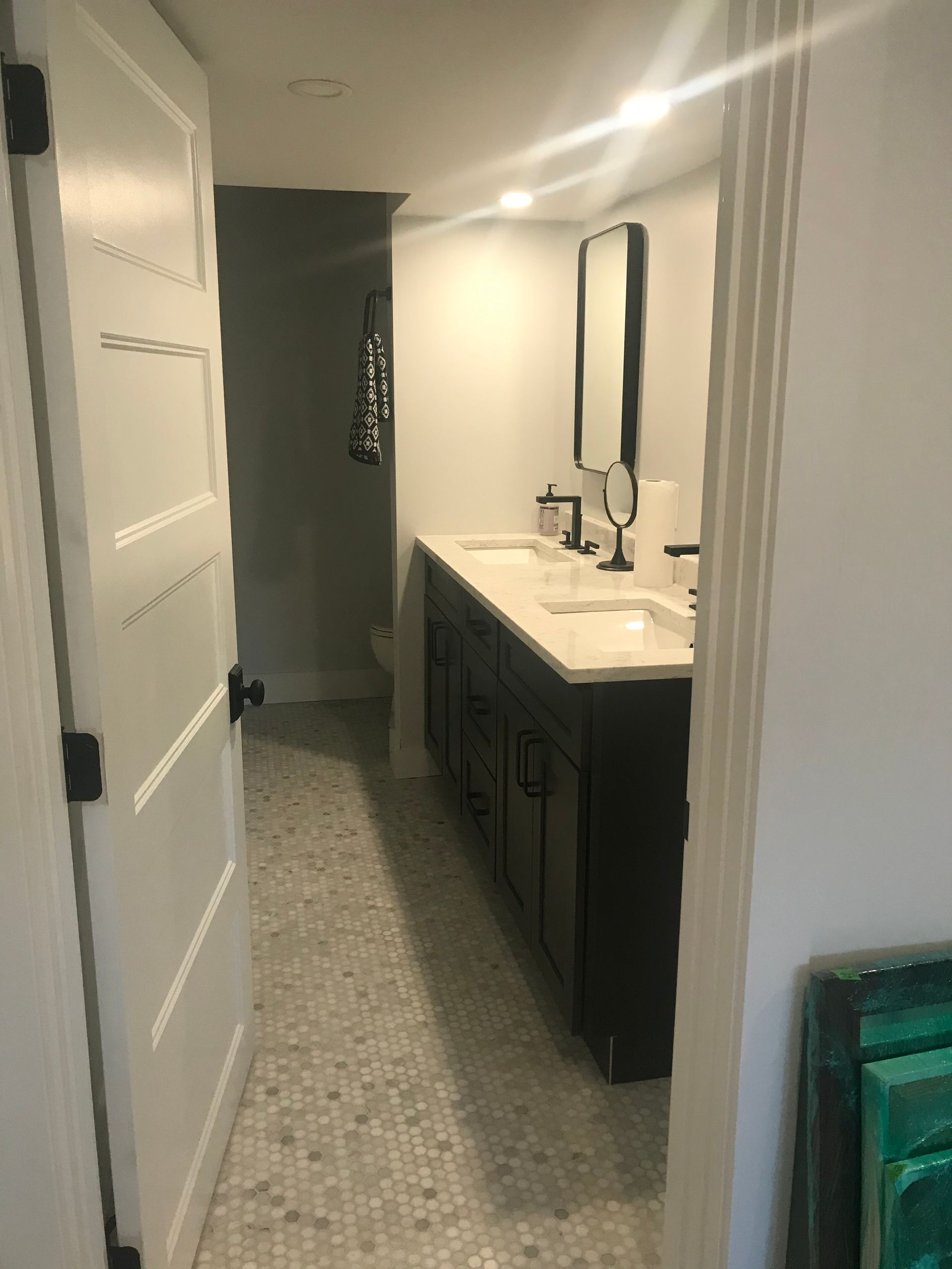 A bathroom with two sinks, a mirror, and a toilet.