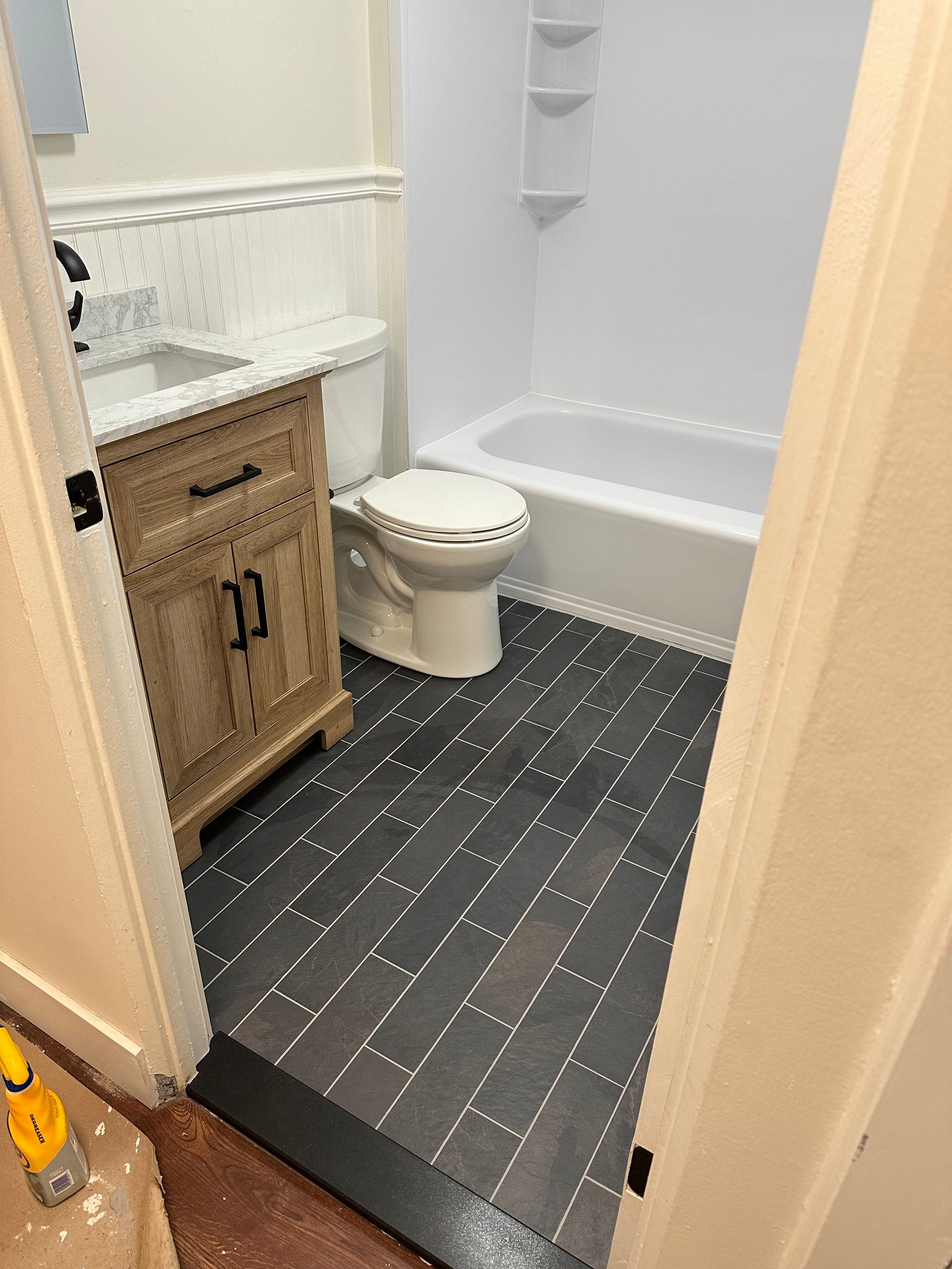 A bathroom with a toilet, sink, and bathtub.