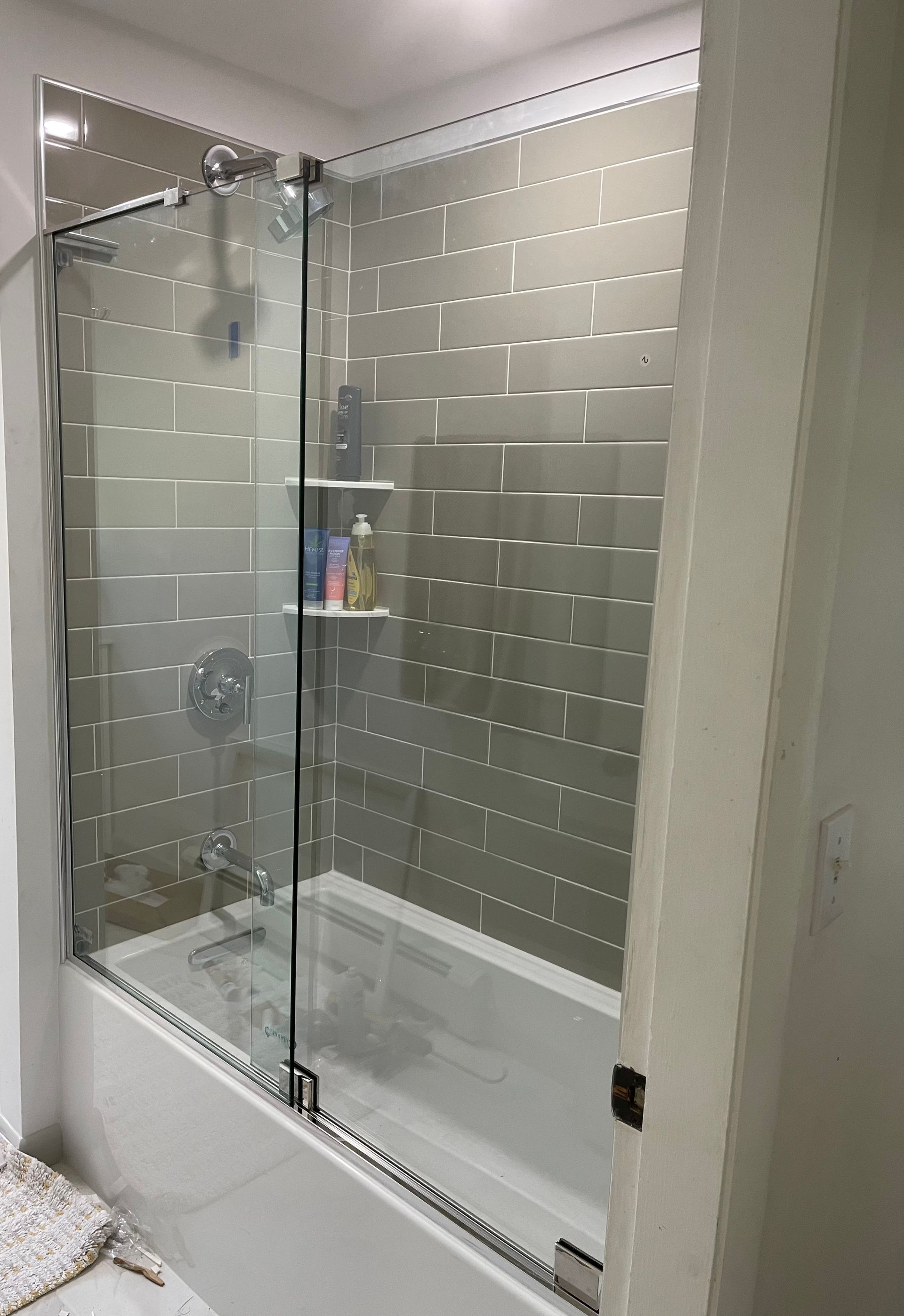 A bathroom with a bathtub and a glass shower door.