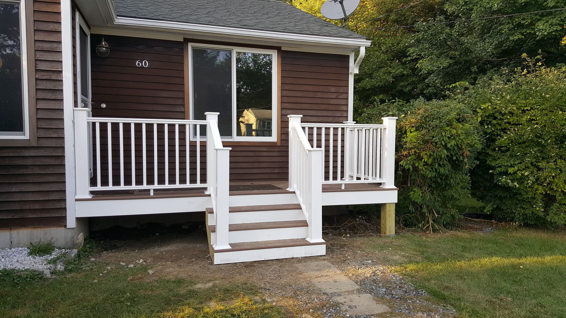 A brown house with a white porch and stairs.