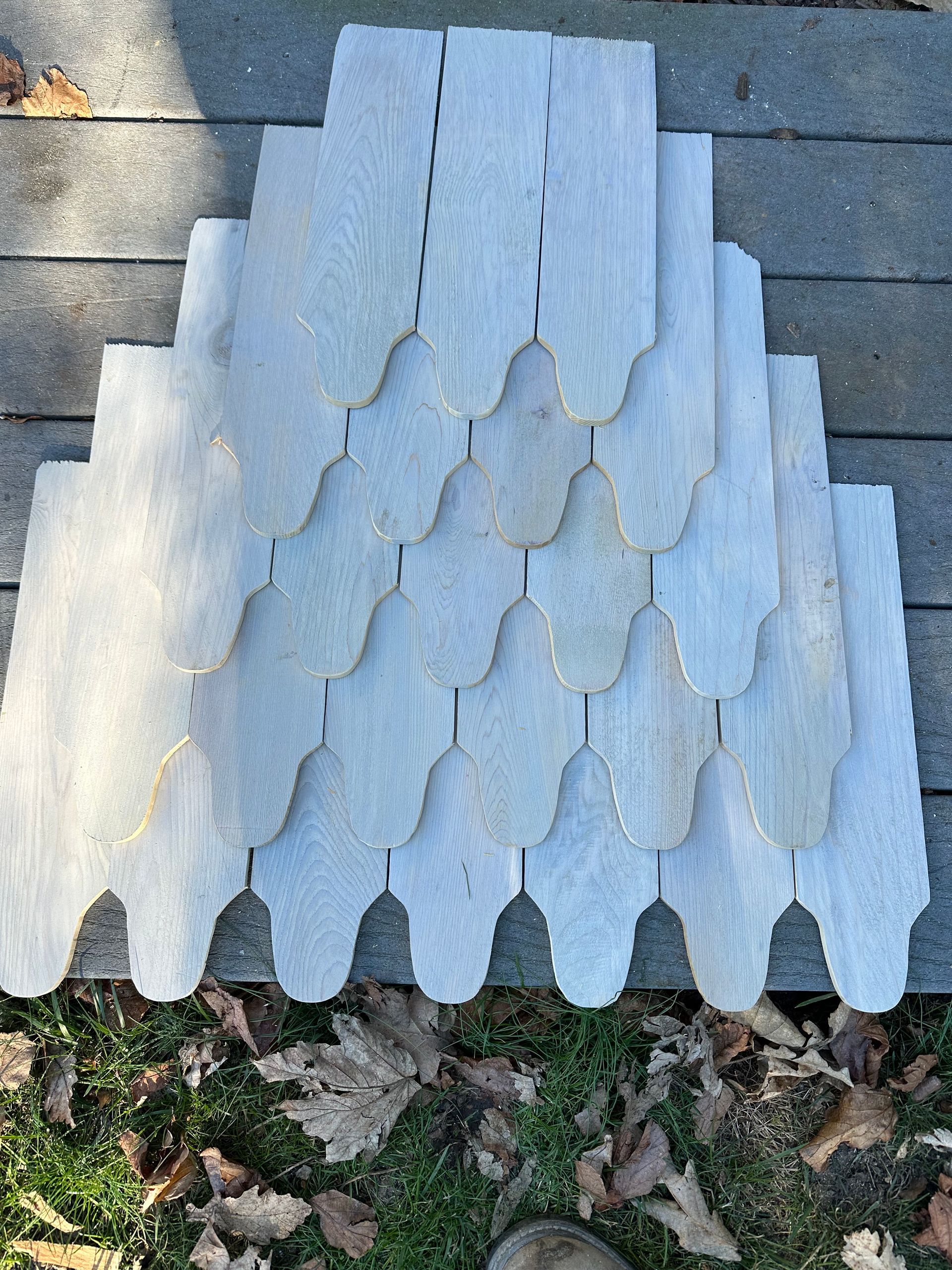 A stack of white shingles sitting on top of a wooden deck.