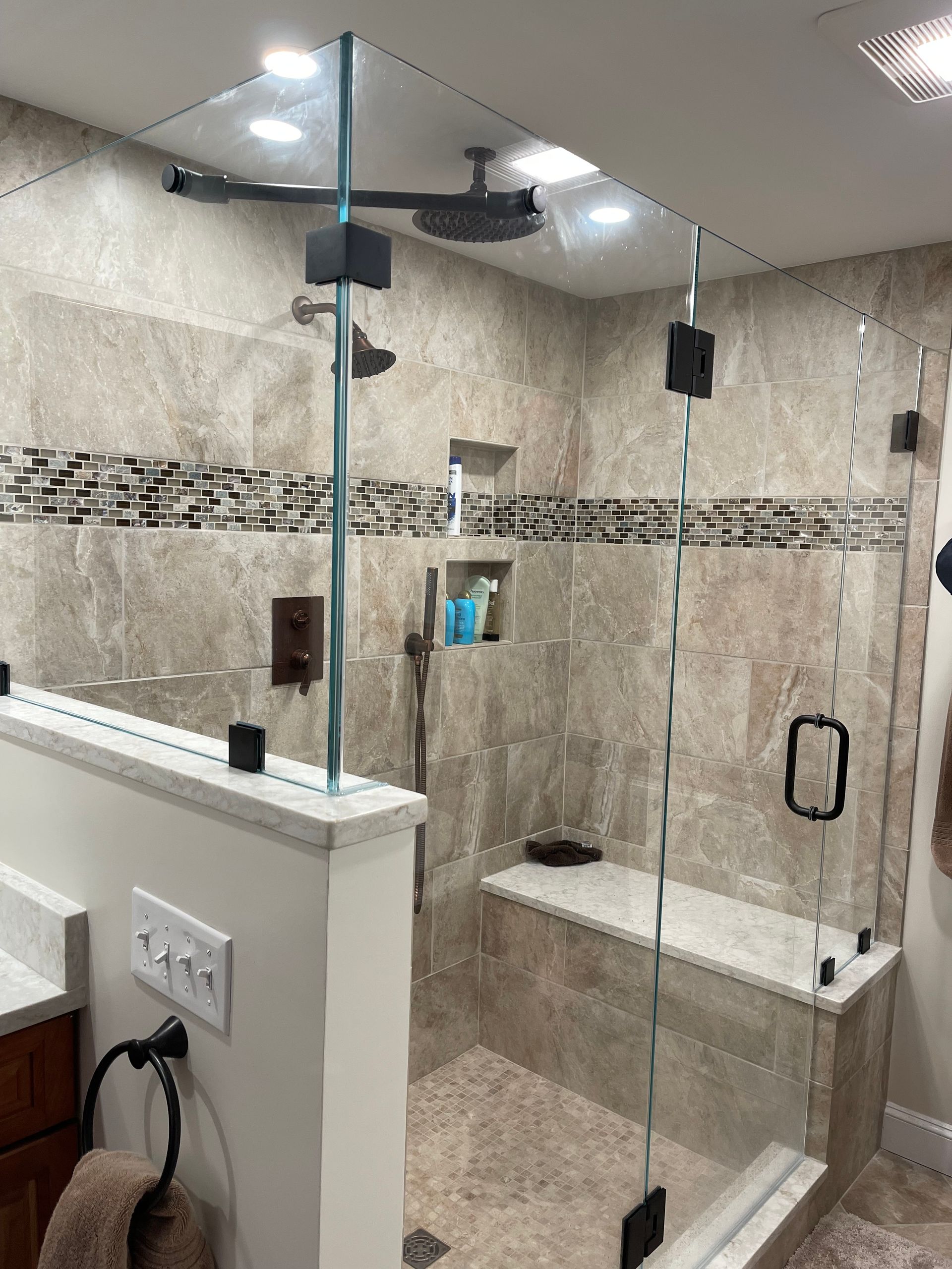 A bathroom with a walk-in shower with a glass door.