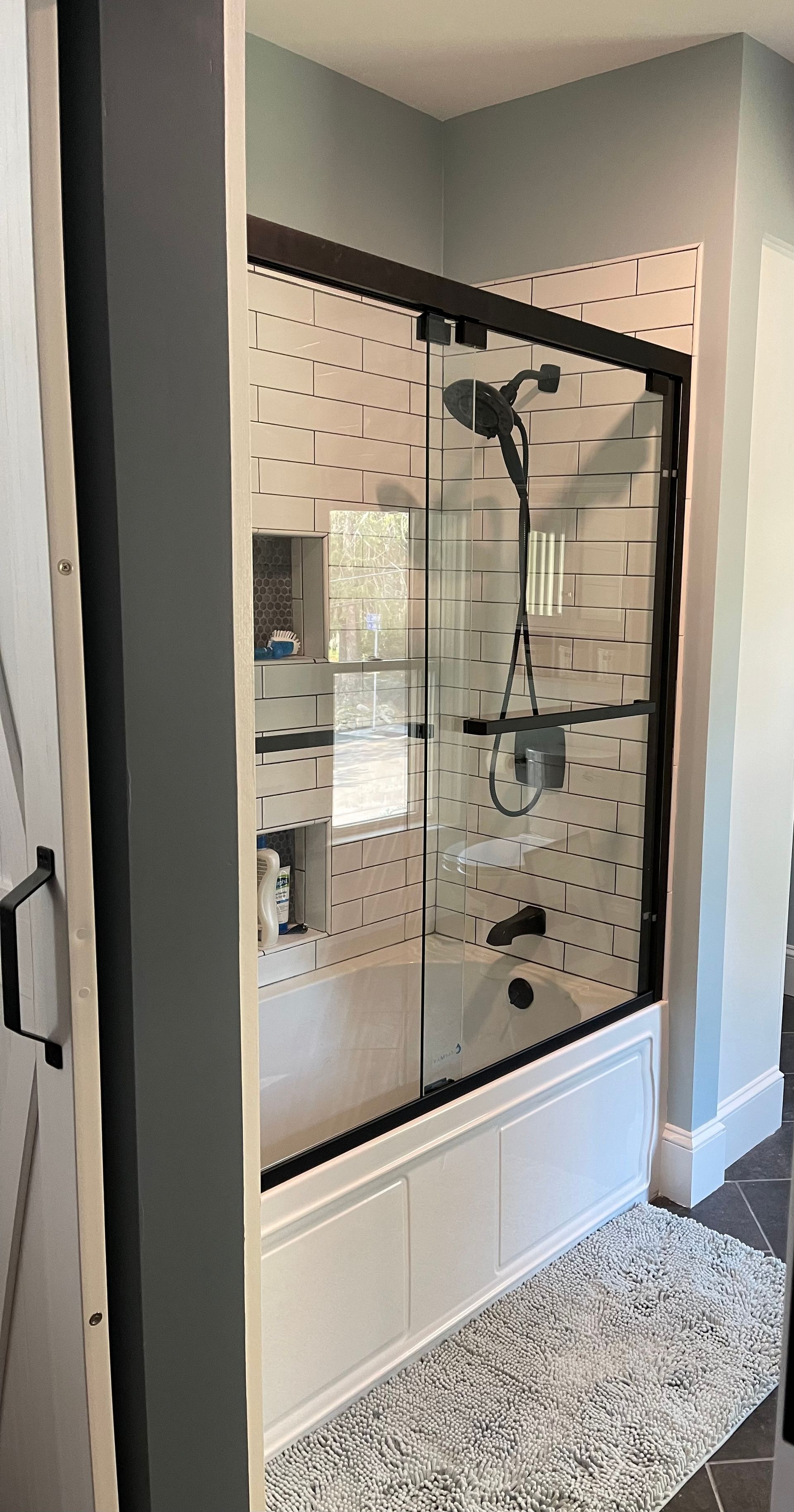 A bathroom with a bathtub and a shower with a sliding glass door.