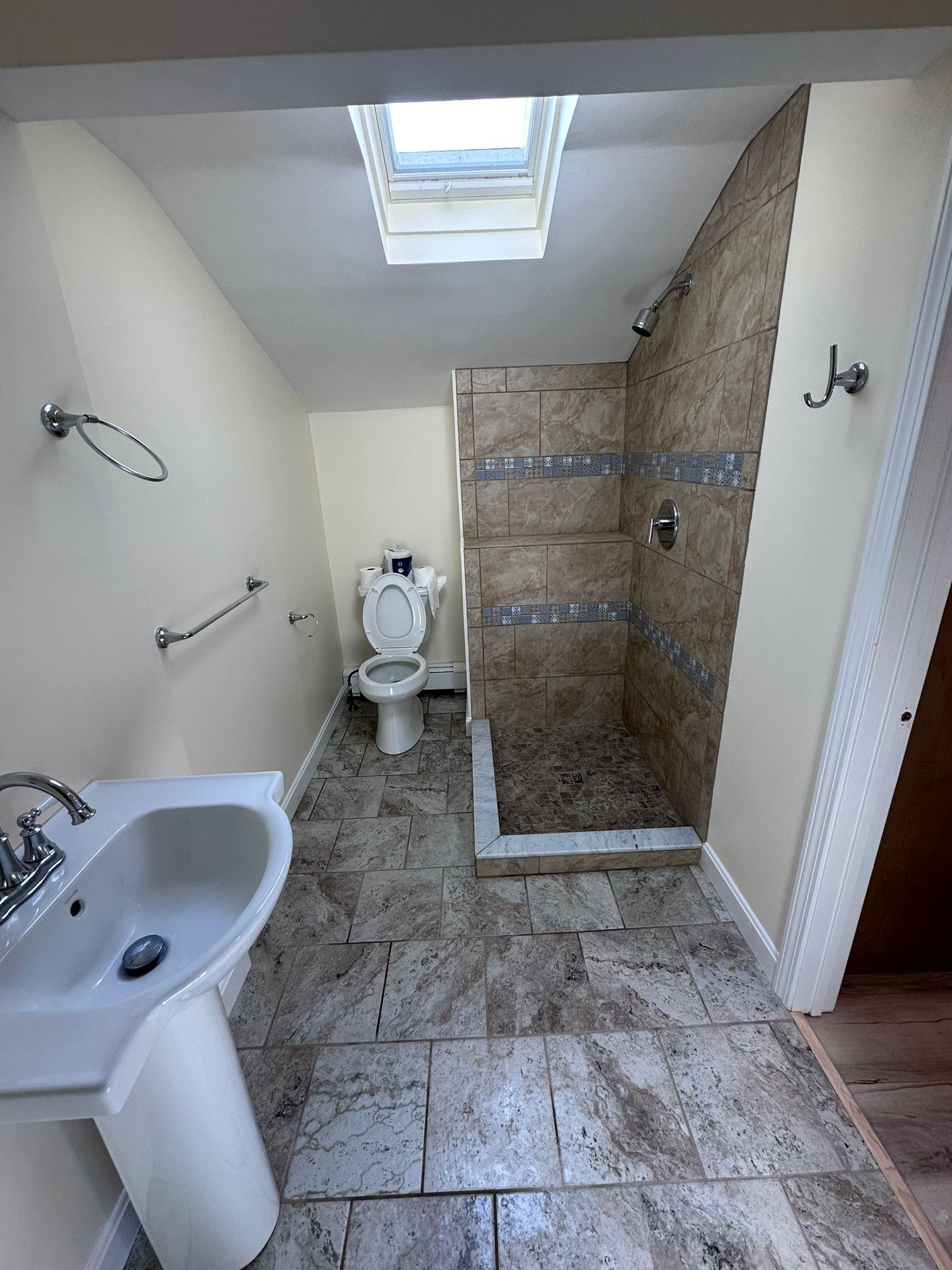A bathroom with a toilet, sink, and shower.