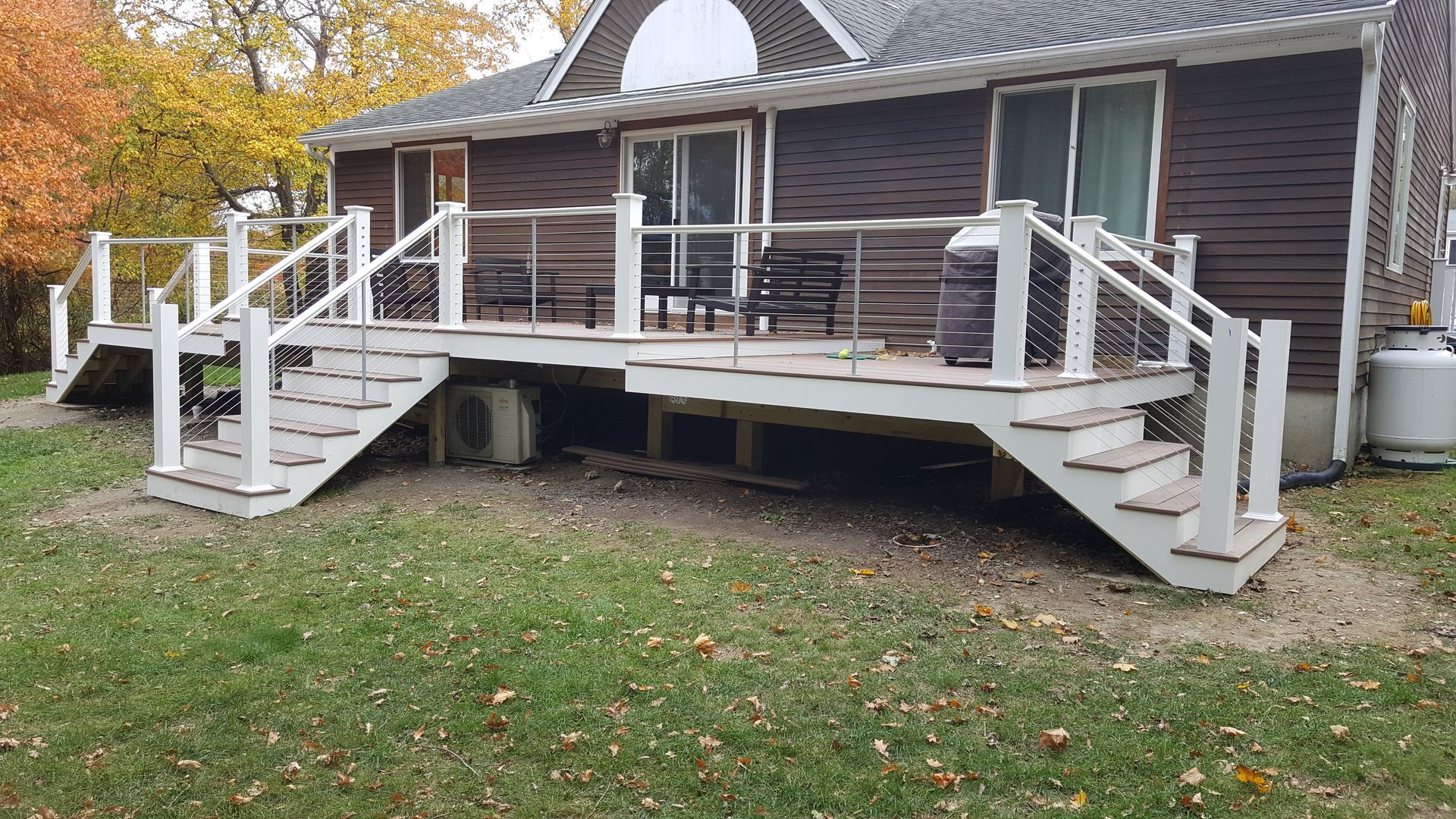 A house with a large deck and stairs in front of it.