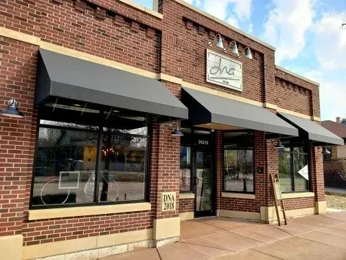 Brick building with black awnings and large windows, 
