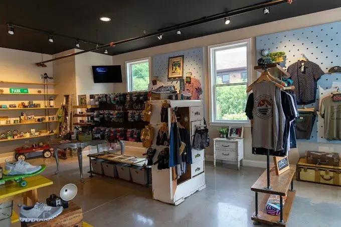 Interior of a retail store with clothing and merchandise on display; blue wall with polka dots, shelves of goods.