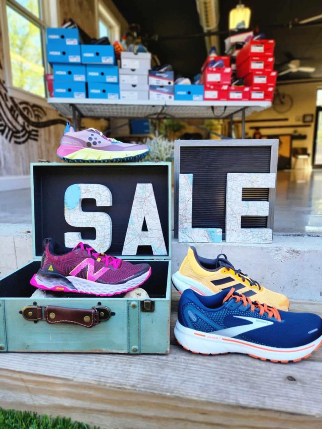 Shoes on display for sale in a store; various colors, including purple, yellow, and blue.
