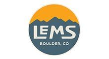 LEMS Boulder, CO logo. Dark blue circle, yellow top section with mountain silhouette, white text.