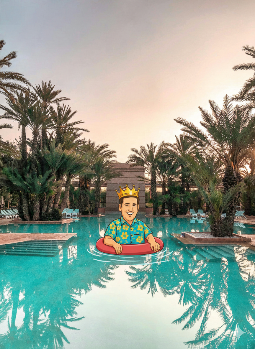 Person with crown floats in pool surrounded by palm trees at sunset.