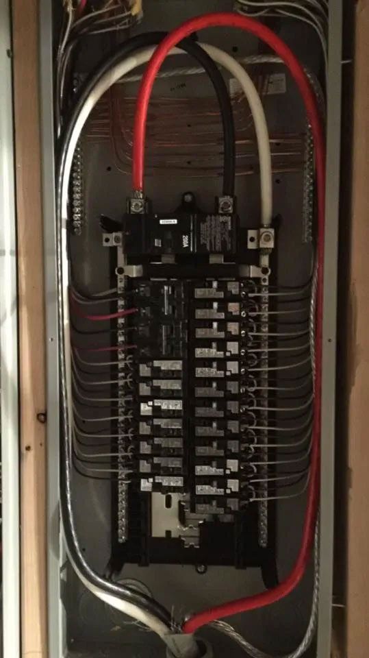 Electrical panel with wires and circuit breakers.