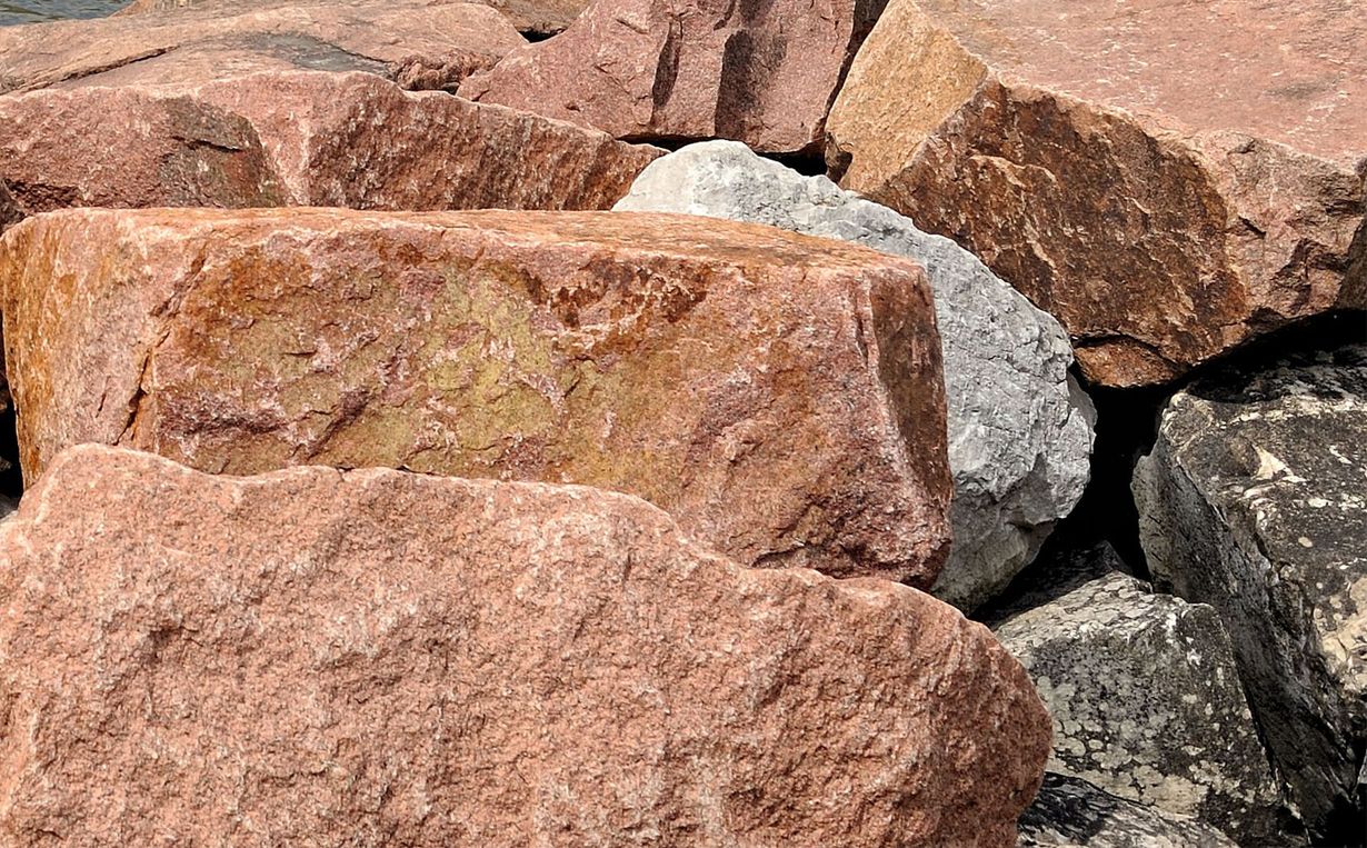 Pile of reddish-brown and gray granite rocks.