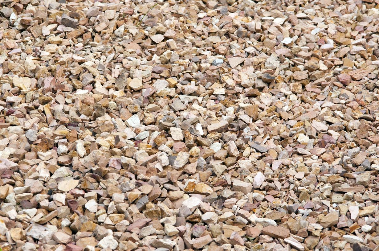 Crushed gravel, tan and beige, covers the ground.