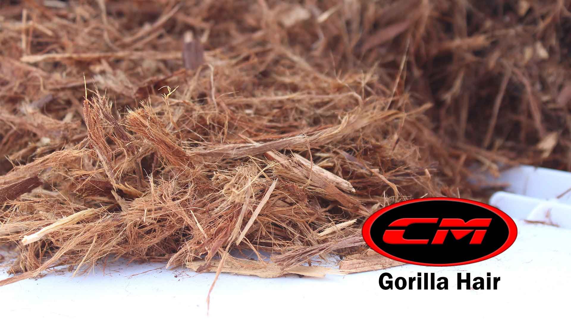 Pile of shredded brown Gorilla Hair mulch with the CM logo.