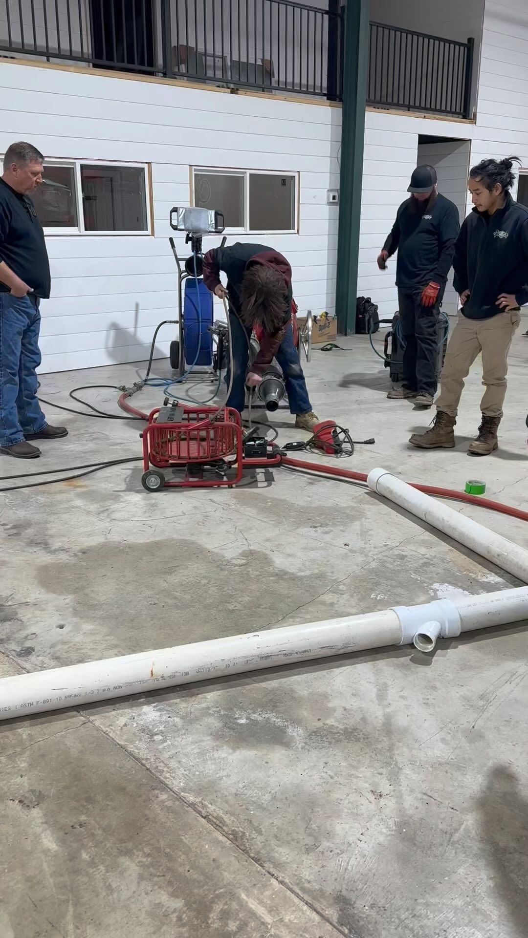 A group of men are working on pipes in a building.