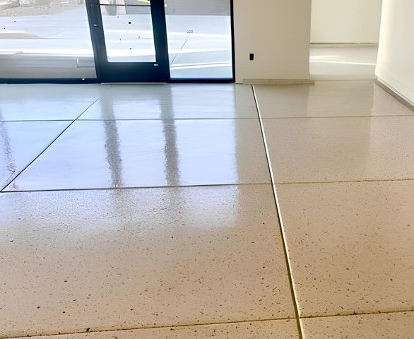 Shiny, light-colored, sealed concrete floor with grid pattern, in a well-lit interior.
