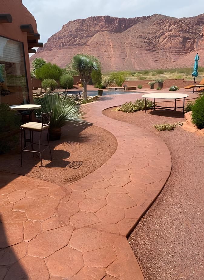 Red stone path winds past outdoor seating and pool with mountain backdrop.