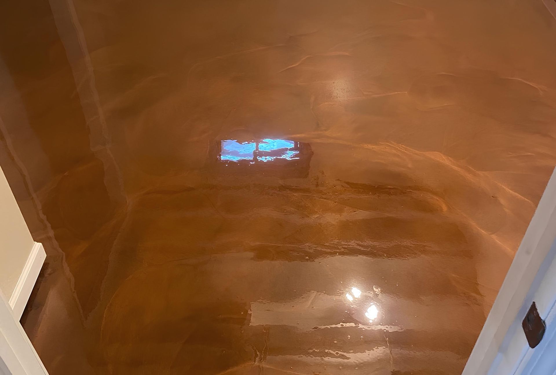 Copper-colored epoxy floor with light reflecting.