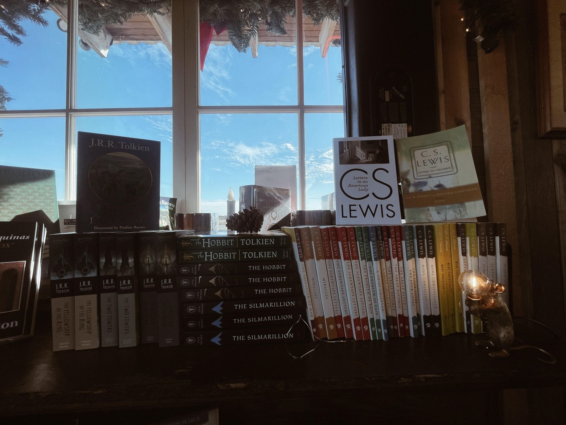 A stack of books on a shelf with a sign that says cs lewis