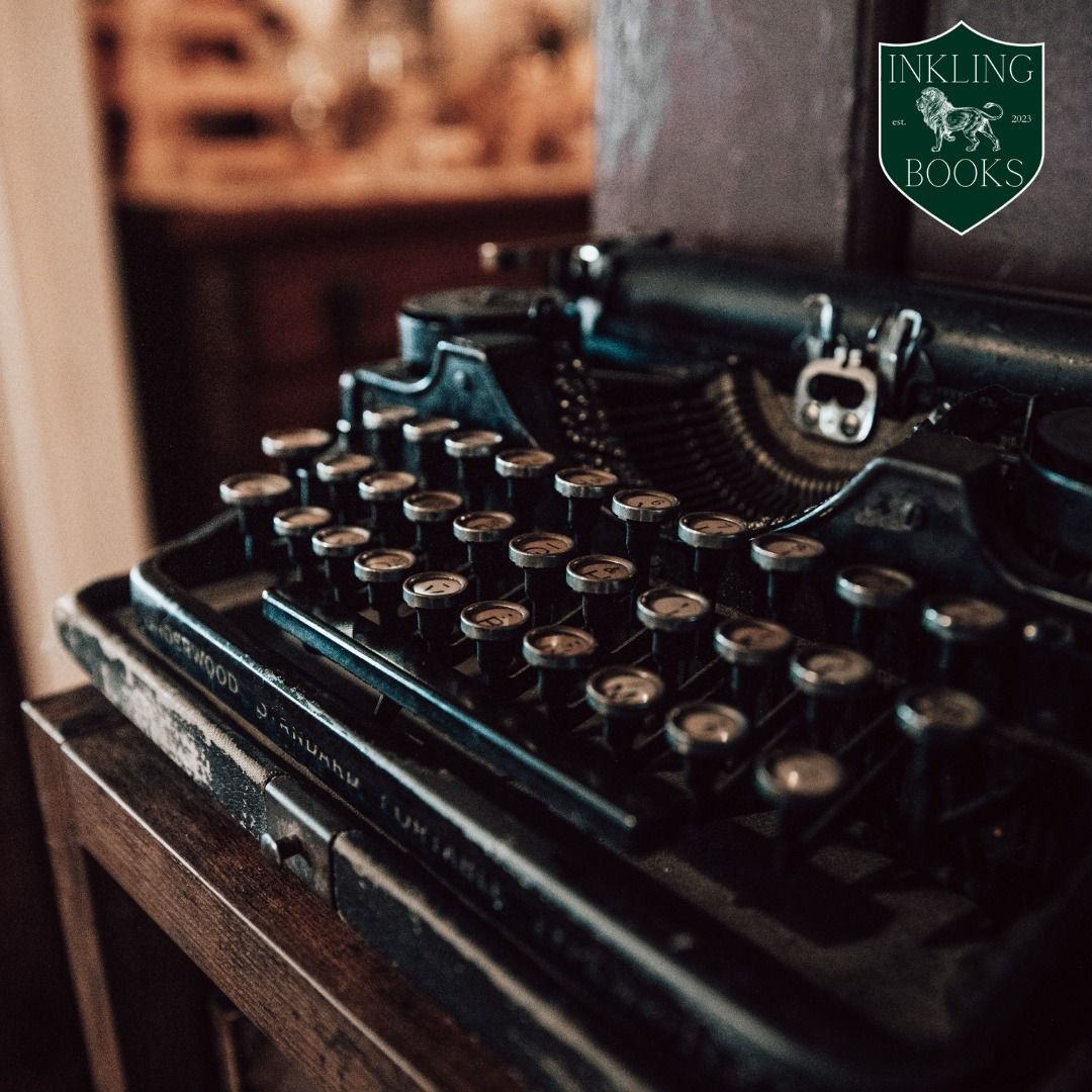 An old typewriter is sitting on a wooden table.