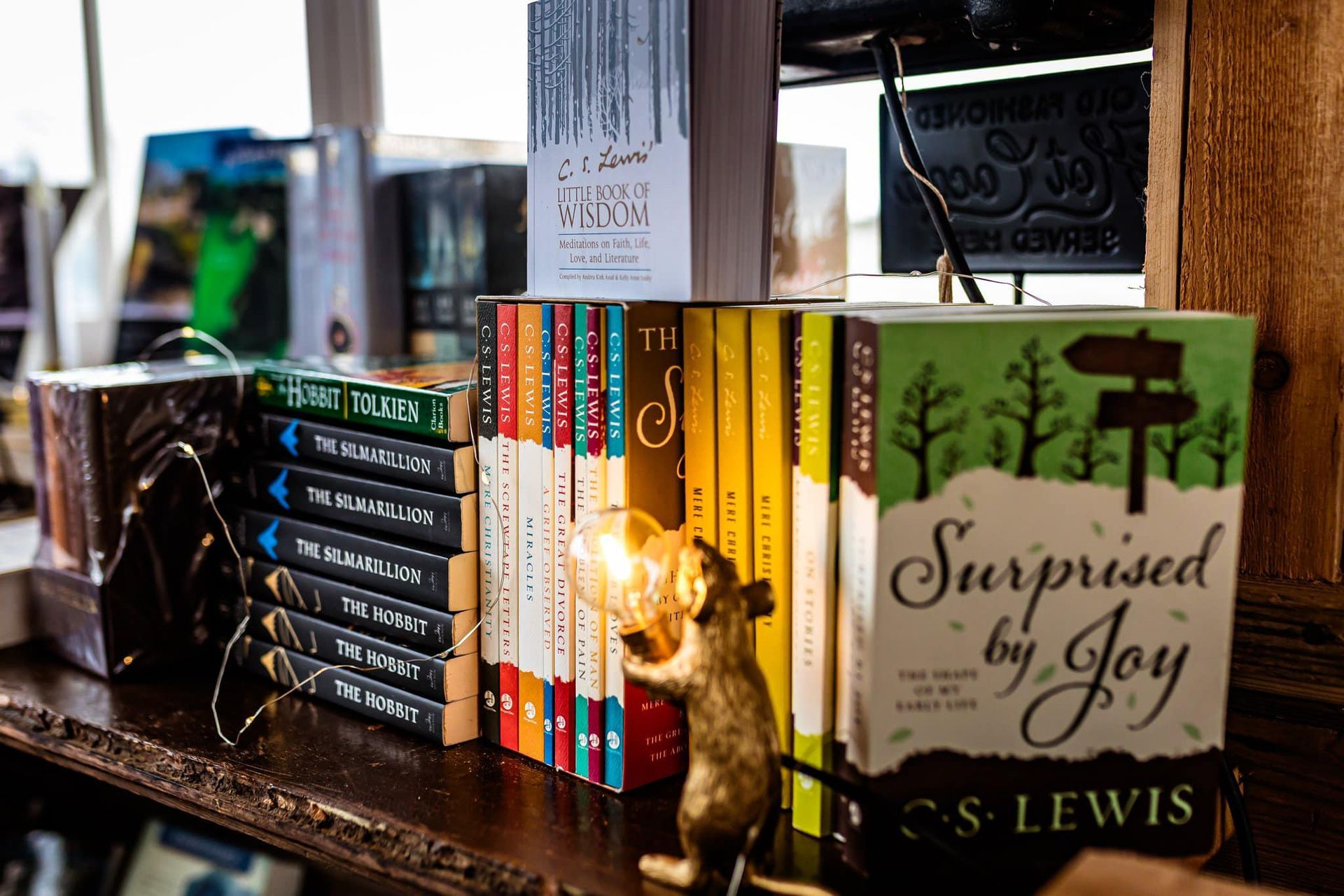 A shelf filled with books including surprised by joy by cs lewis
