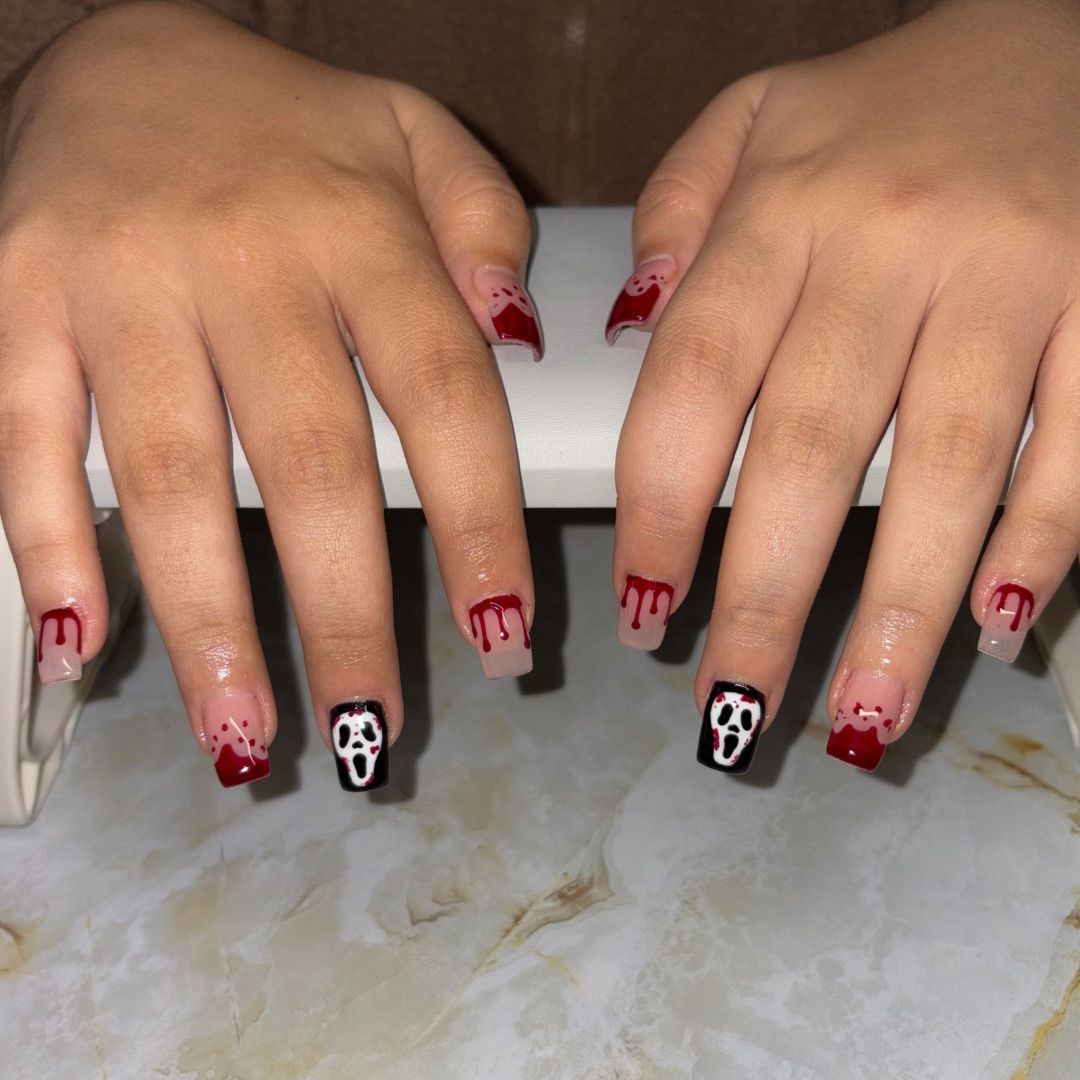 A woman's hands with a scream manicure design.