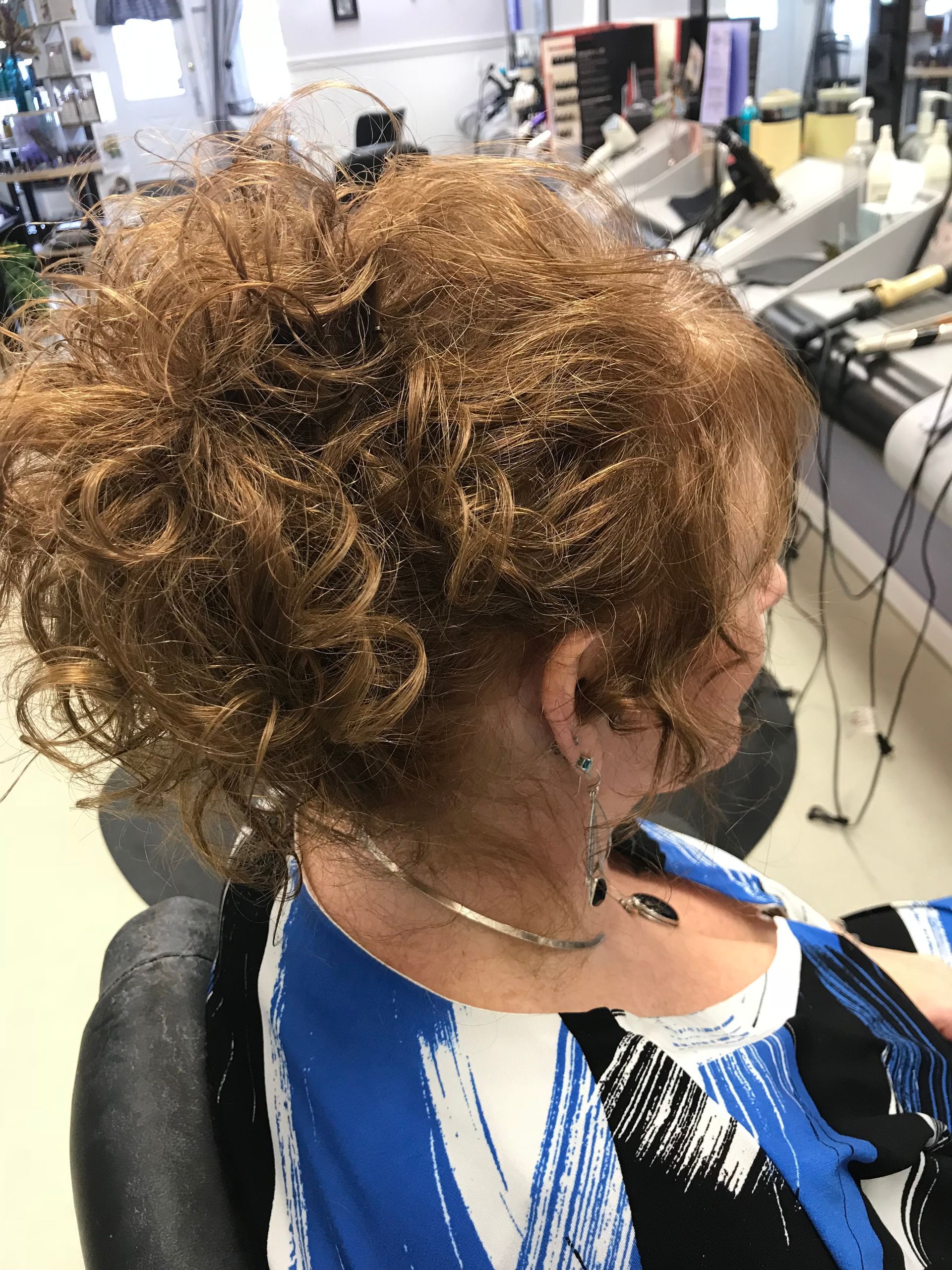 A woman is sitting in a chair with her hair in a ponytail.