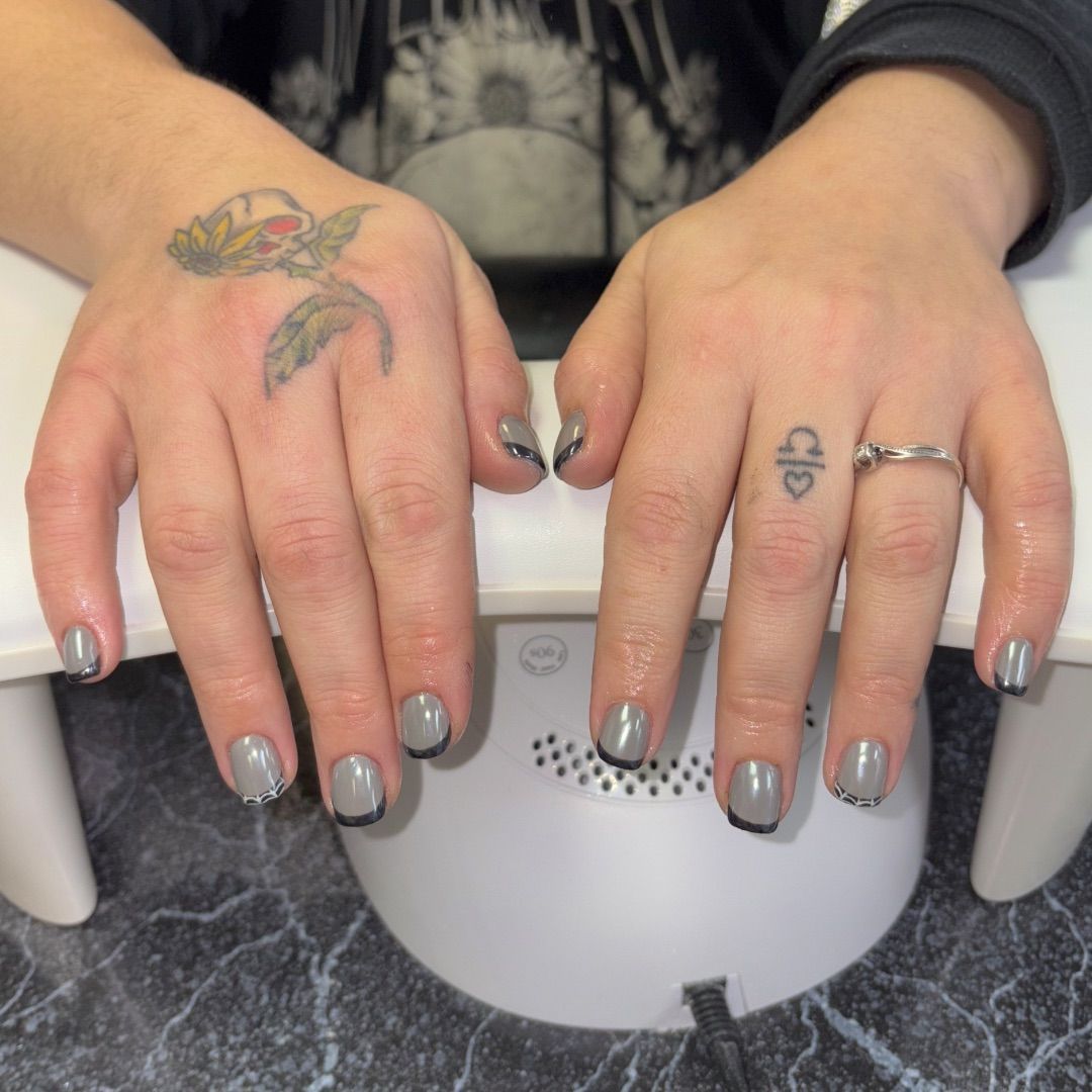 A woman's hands with a grey and black French manicure design.